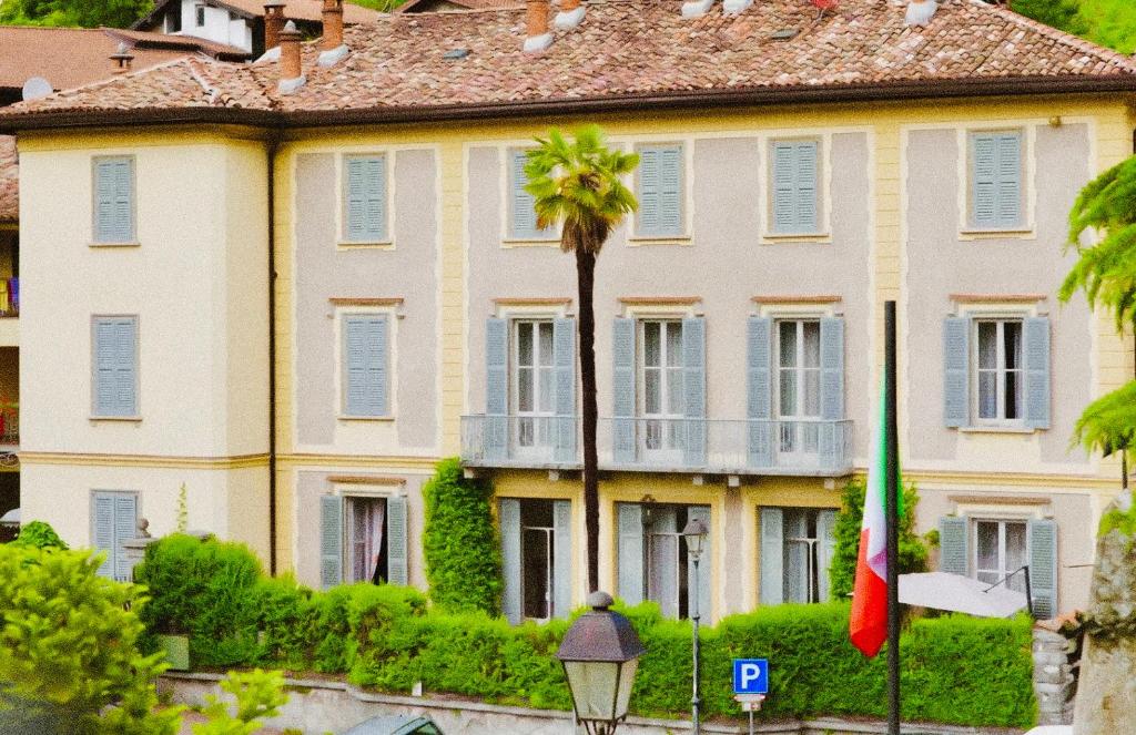 Lasnigo的住宿－Villa Ruscone，一座大房子,前面有棕榈树