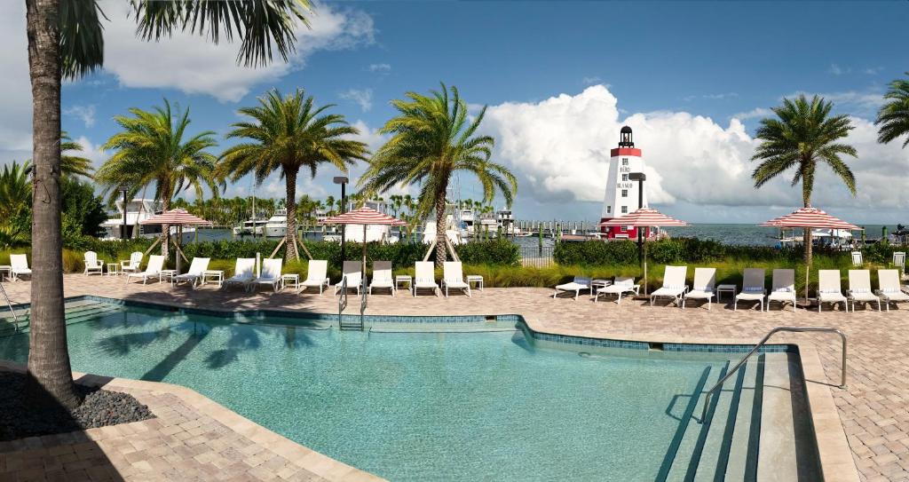 a pool with chairs and a lighthouse in the background at Faro Blanco Resort & Yacht Club in Marathon