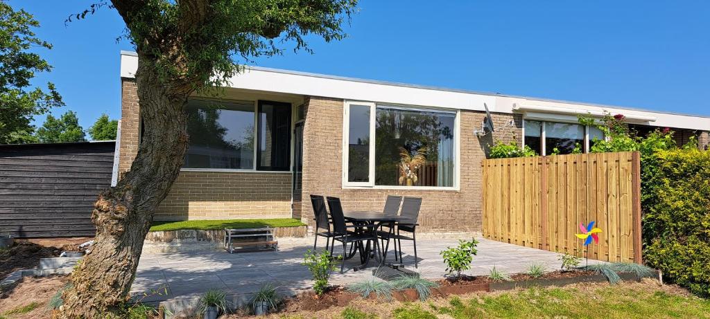 een huis met een tafel en stoelen op een patio bij Bungalow Plattedijk 25-34 in Lemmer