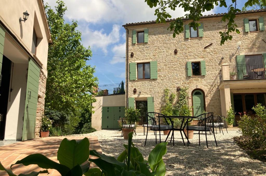 Cupramontana的住宿－Villa Verdicchio - B&B for winelovers，享有带桌椅的大楼的外部景致