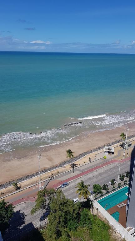 uma vista para a praia e para o oceano a partir de um edifício em Flat em Boa Viagem - perto da praia no Recife