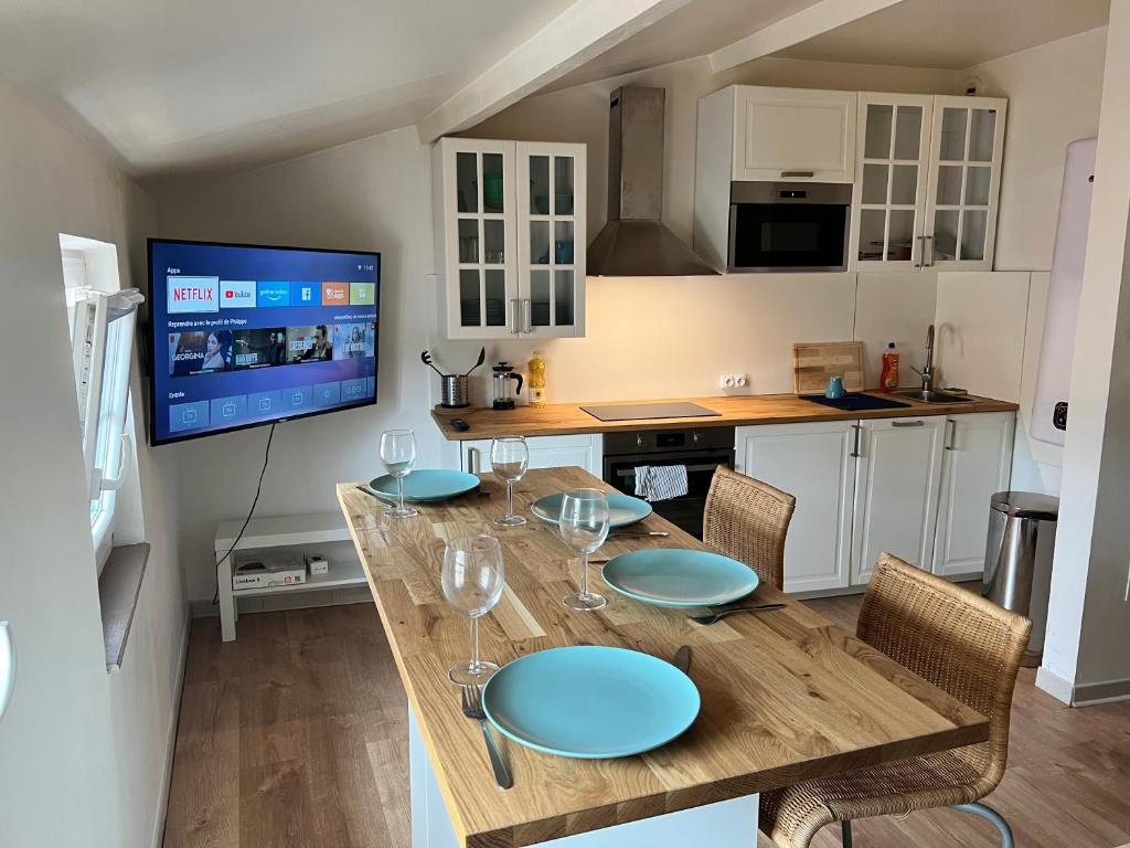 Il dispose d'une télévision et d'une cuisine avec une table et des verres à vin. dans l'établissement T1Bis Neuf Climatisé CentreVille #15, à Toulon