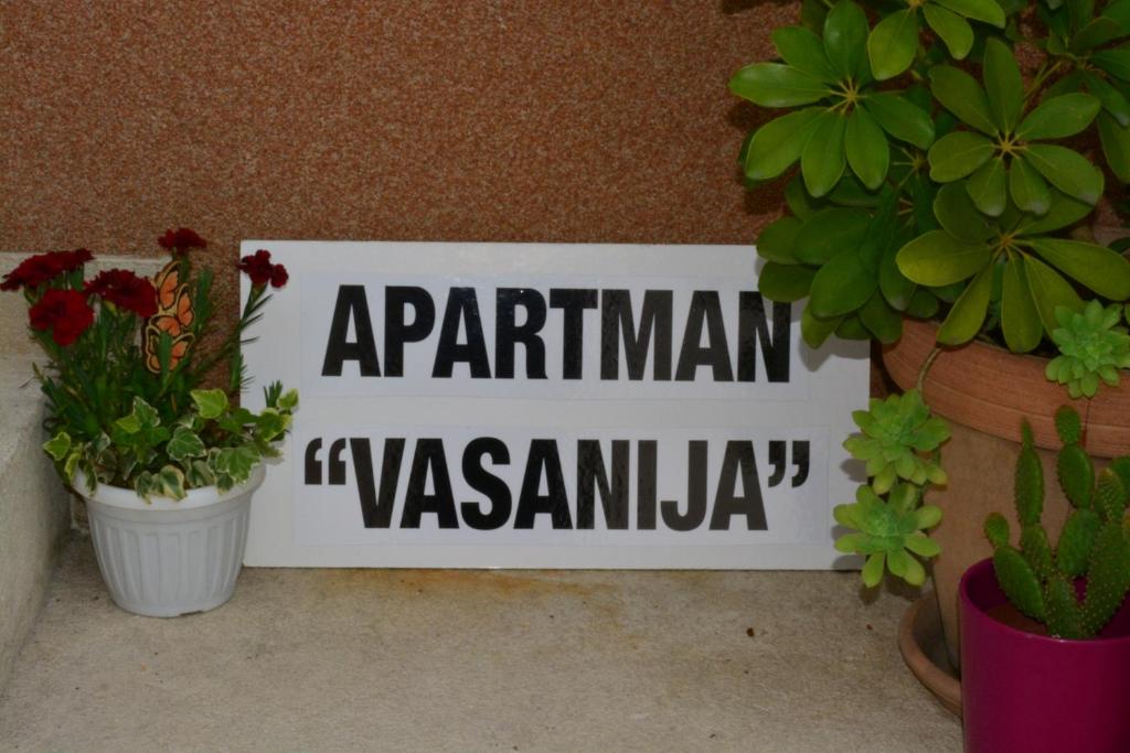 un cartello su un muro con piante e fiori in vaso di Apartman Vasanija a Opatija