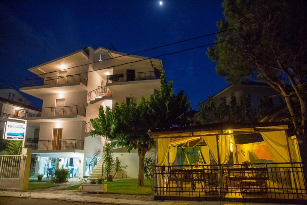 un edificio con una tienda delante de él por la noche en Philoxenia Apartments, en Kryonéri