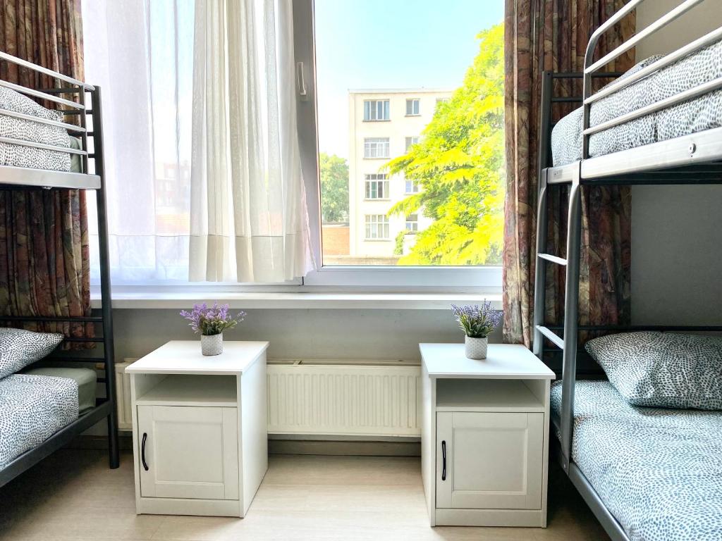 a dorm room with two beds and a window at Apartments Bex. in Antwerp