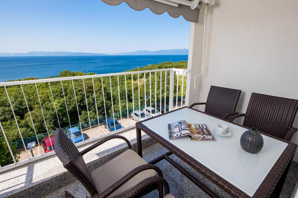 d'une table et de chaises sur un balcon avec vue sur l'océan. dans l'établissement Apartment Kvarner View, à Kostrena
