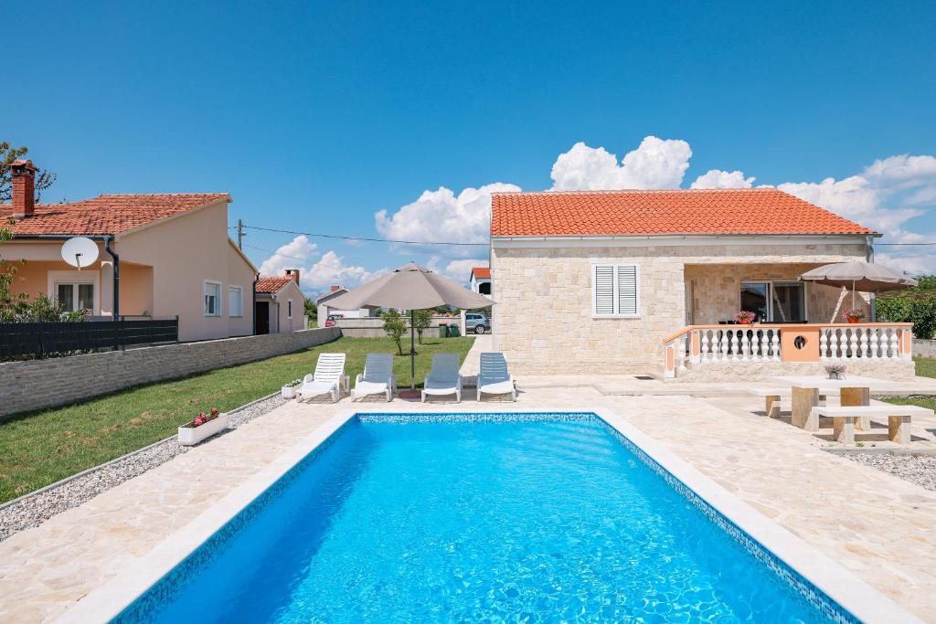 a swimming pool in front of a house at Villa Stone House with Pool in Nin