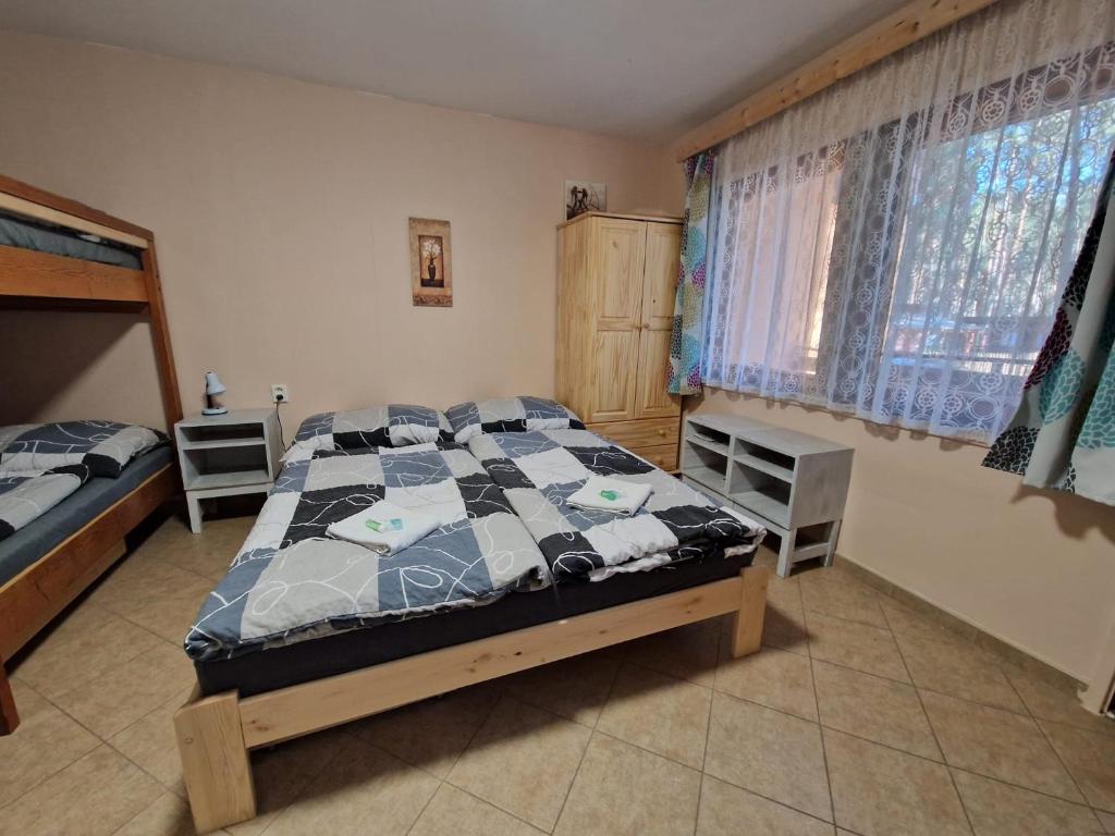 1 dormitorio con 1 cama con edredón en Chatky U Davida Máchovo jezero, en Doksy