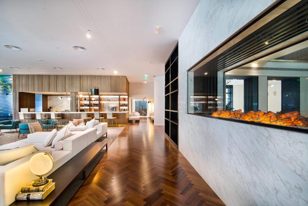 a living room with white furniture and a fireplace at Le Meridien Abu Dhabi in Abu Dhabi