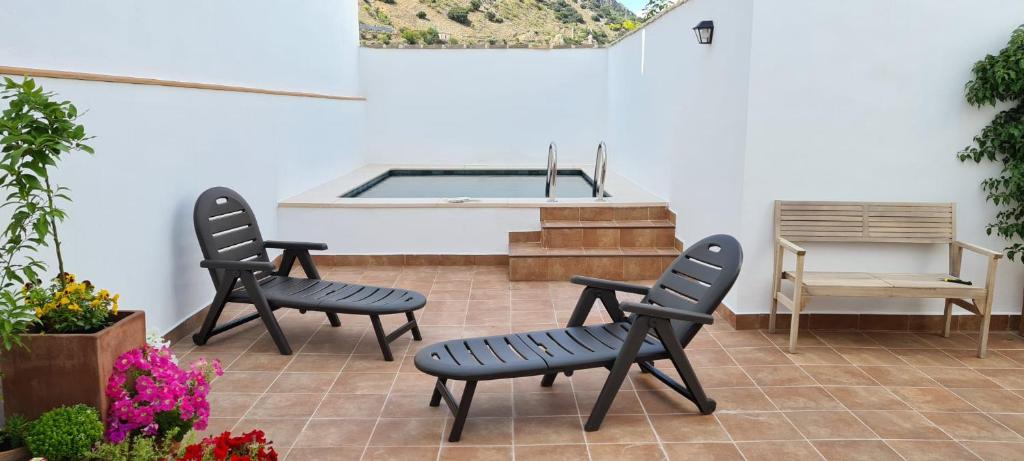 um pátio com 2 cadeiras e uma piscina em Casa La Oliva em Albanchez de Úbeda