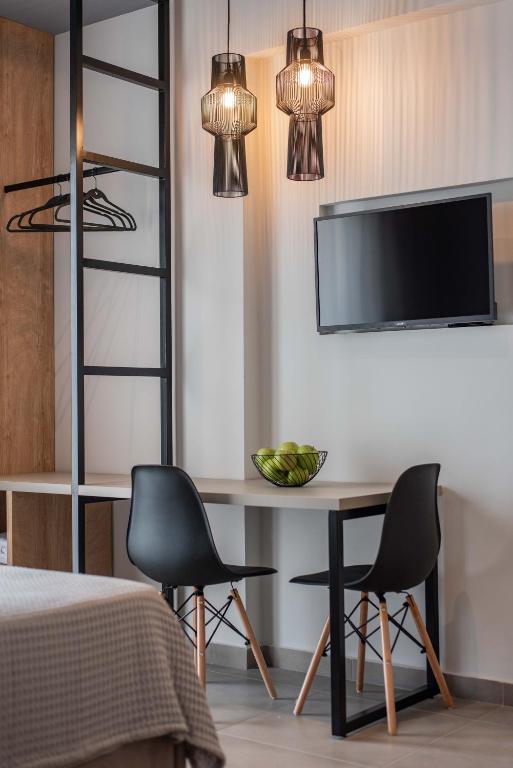 a bedroom with a table and two chairs and a tv at Val Del Mar in Skala Fourkas