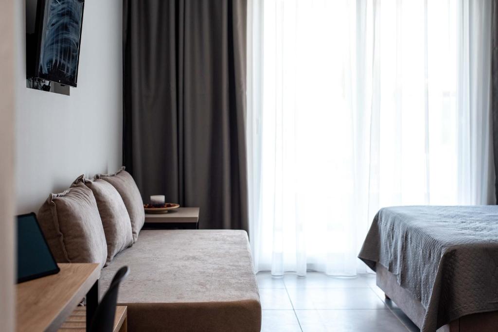 a bedroom with a couch and a bed and a window at Val Del Mar in Skala Fourkas