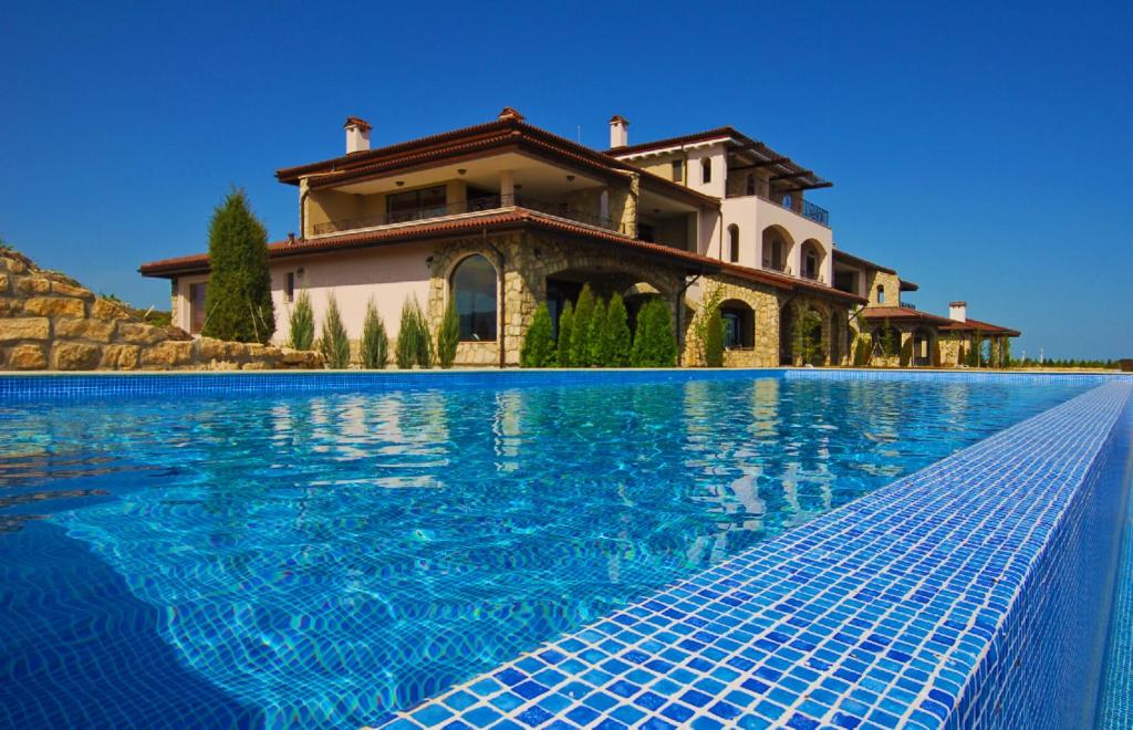 uma casa com uma piscina em frente em Club Residence at BlackSeaRama Golf em Balchik