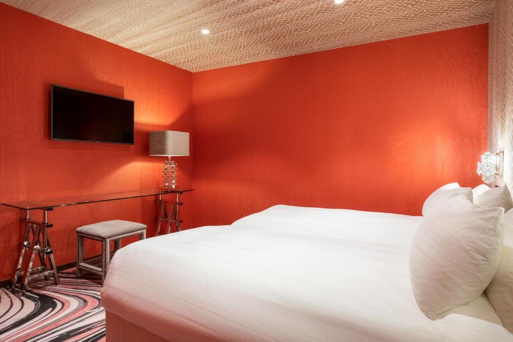 a red bedroom with a bed and a desk at Apollo Hotel Amsterdam, a Tribute Portfolio Hotel in Amsterdam