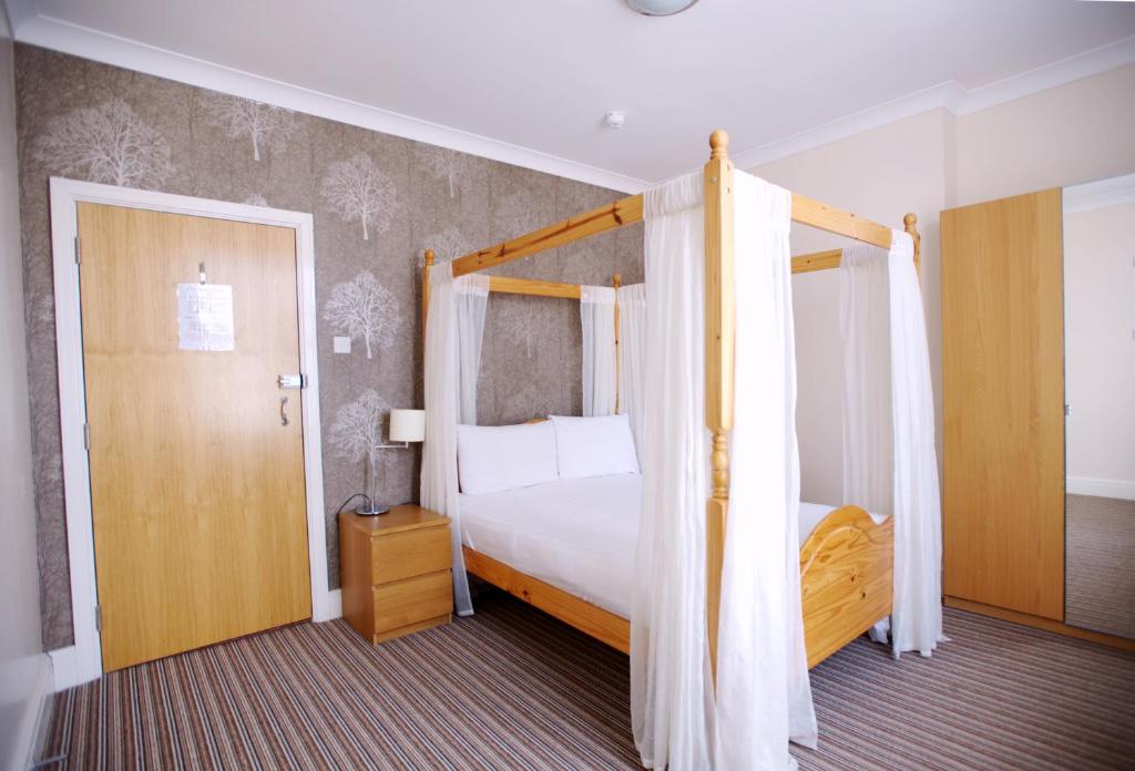 a bedroom with a bed and a canopy bed at Ashley Victoria in Blackpool