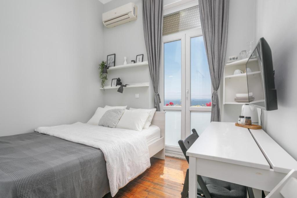 een slaapkamer met een bed, een bureau en een raam bij Room Gloria in Opatija