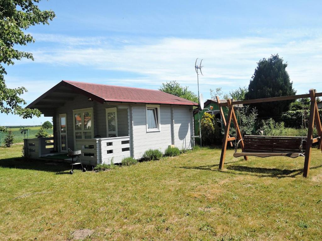 a small house with a playground and a swing at Bungalow, Wrzosowo in Wrzosowo