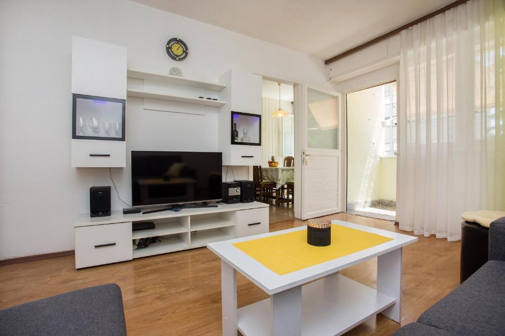 a living room with a flat screen tv and a table at Apartment Jase in Split