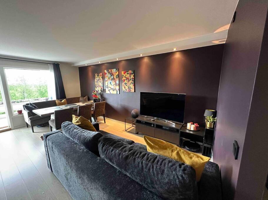a living room with a couch and a flat screen tv at Nyoppusset 2 roms leilighet til leie på Rykkinn in Bærums Verk