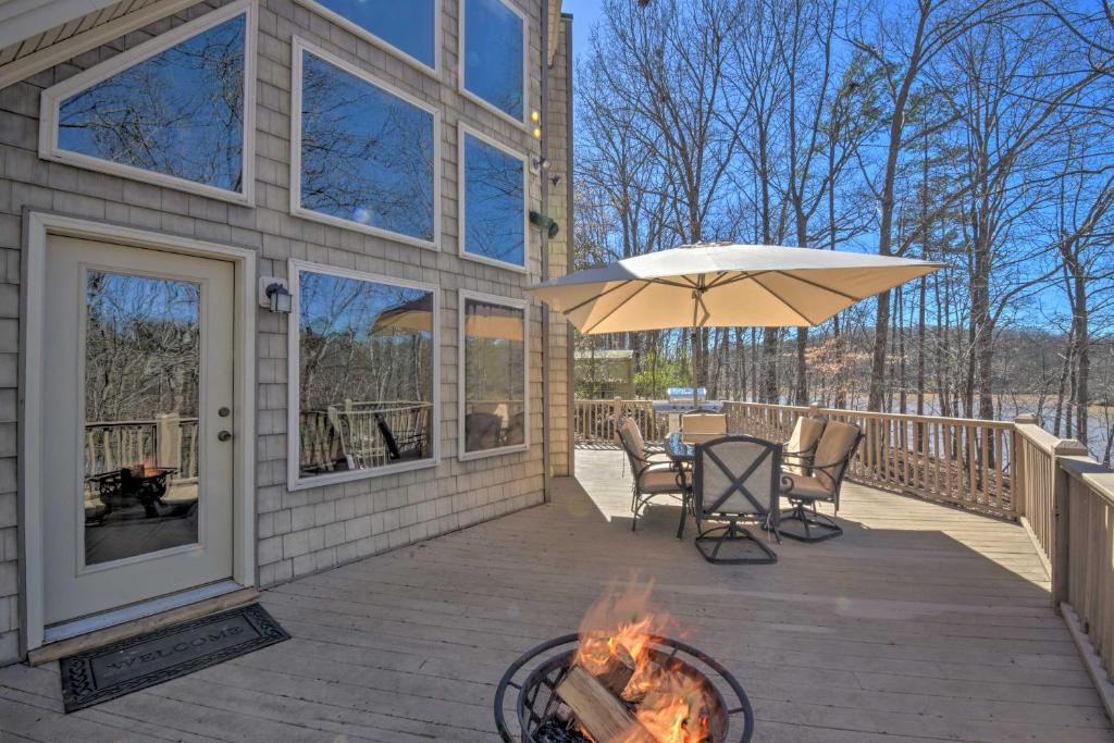 a patio with a table and an umbrella and a grill at Murrayville Lakefront Cabin with Boat Slip and Grill! in Murrayville