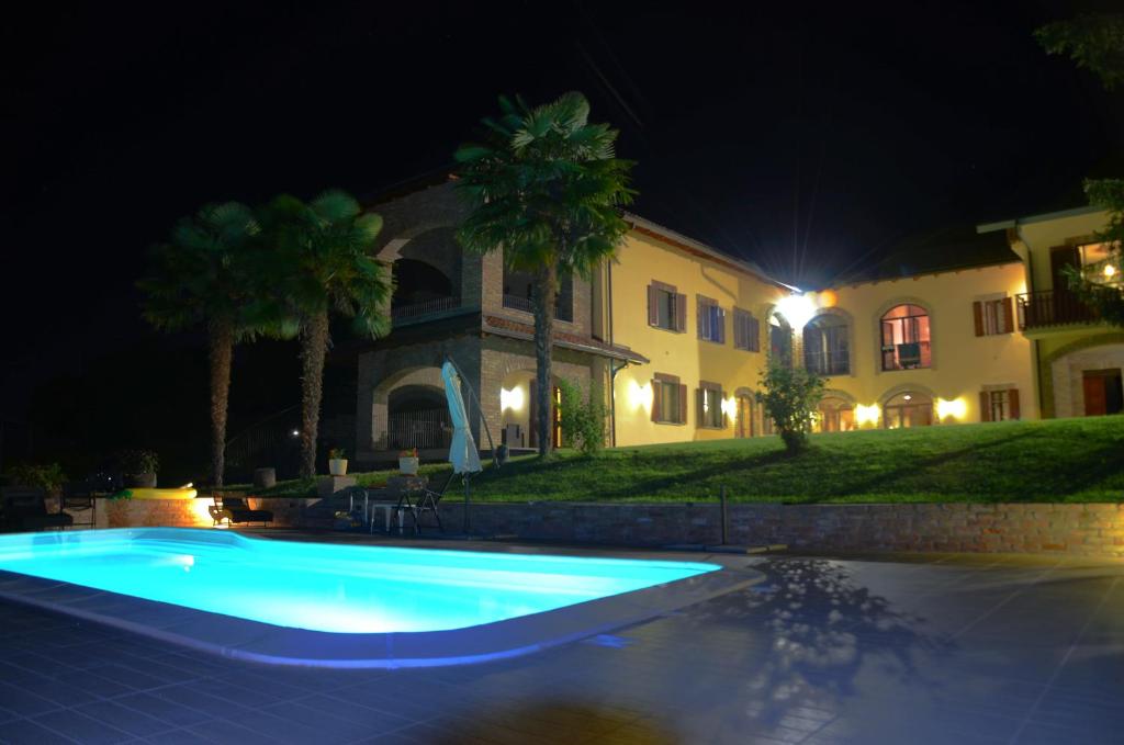 una piscina di fronte a una casa di notte di LA CASA IN CAMPAGNA esclusiva a Calosso