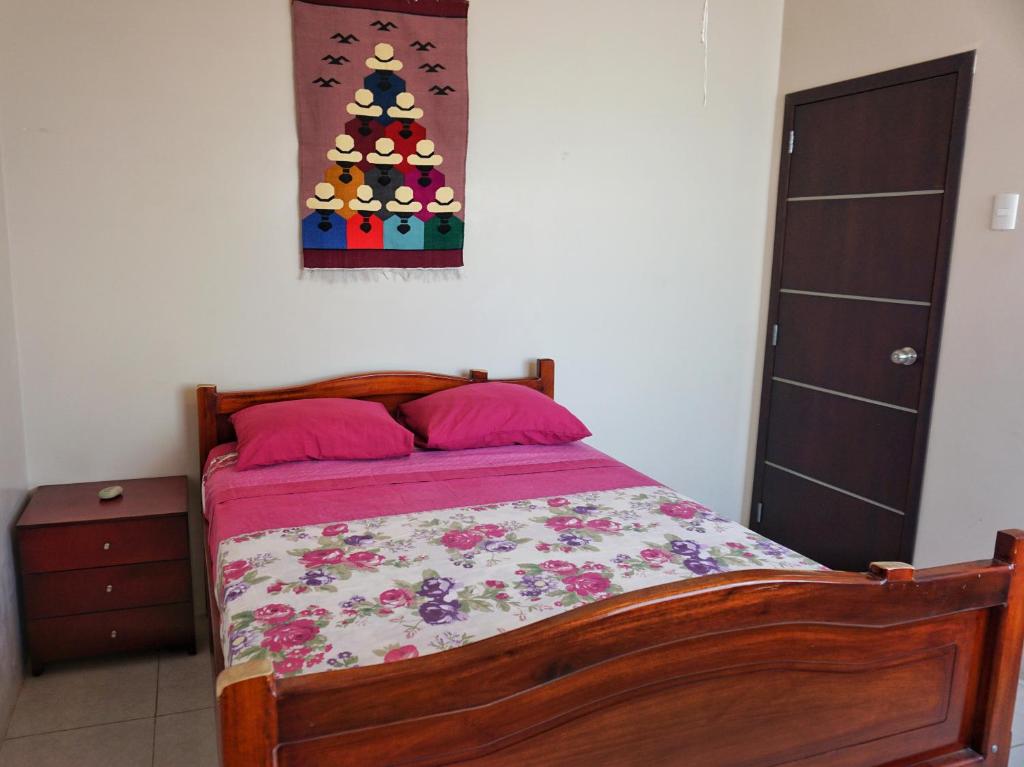 um quarto com uma cama com uma árvore de Natal na parede em Casa Ballena em Crucita