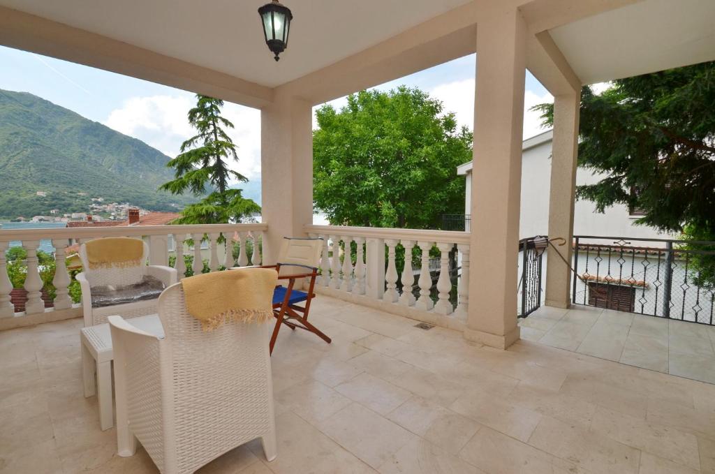 a patio with a table and chairs on a balcony at Nikola - Two Bedroom Ap. with SeaView in Kotor
