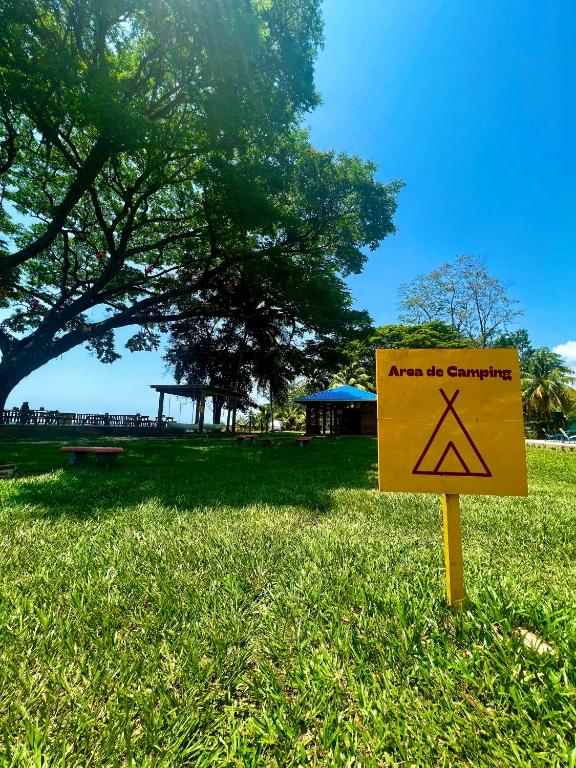 a yellow sign in the grass in a park at Sunset Hut Hostel in Omoa