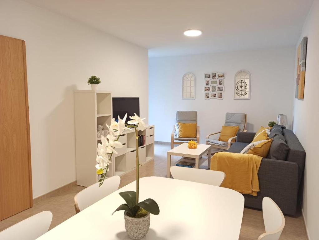 ein Wohnzimmer mit einem Sofa, einem Tisch und Stühlen in der Unterkunft Apartamento Bolboretas con parking privado in Ares