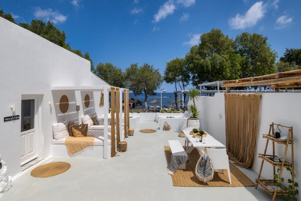 un patio con muebles blancos y vistas al océano. en Sol Mare Salis, en Kamari