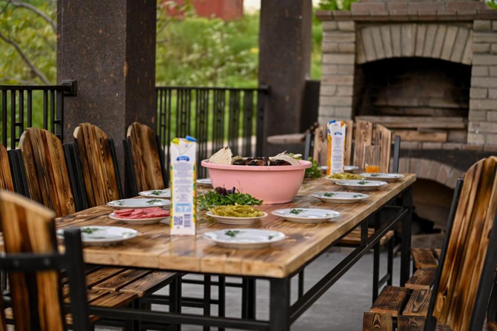 a wooden table with plates of food on a patio at Guest House Climbing 