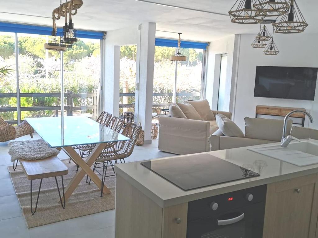 Il comprend une cuisine et un salon avec une table. dans l'établissement Rez-de-jardin terrasse de 100m², au Grau-du-Roi