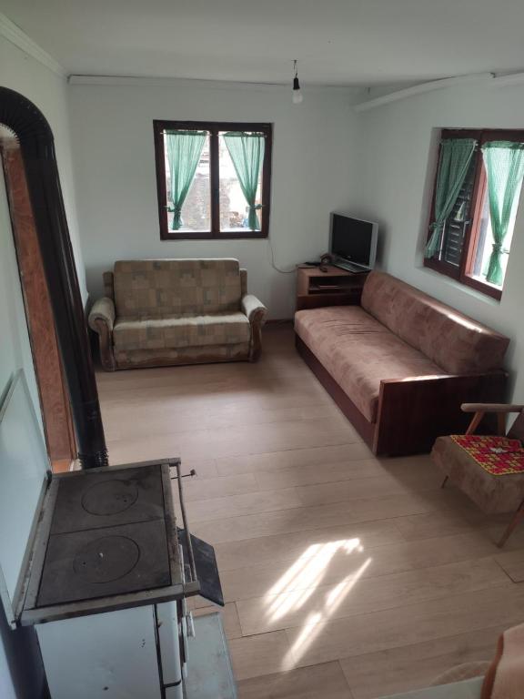 uma sala de estar com um sofá e uma televisão em Kuca idealna za odmor i uzivanje u Vrdniku broj 4 em Vrdnik