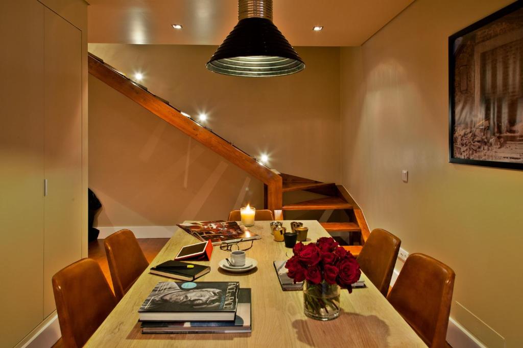 a dining room table with a vase of roses on it at Lisbon Five Stars Apartments São Julião 72 in Lisbon