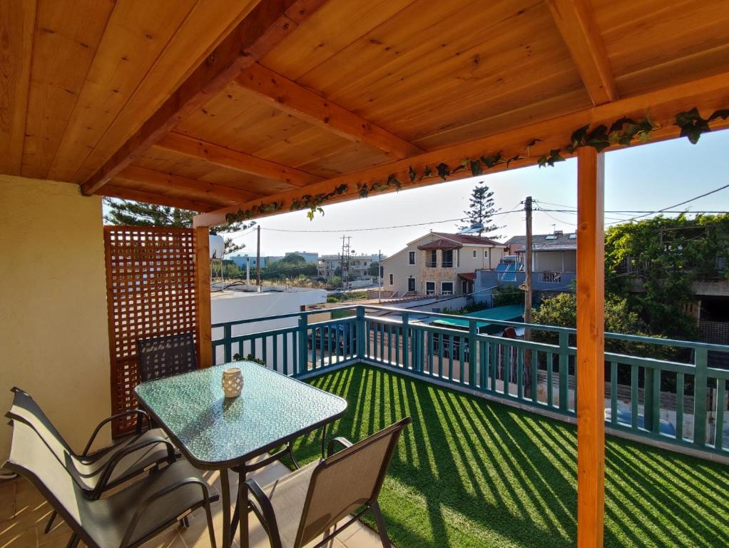 a patio with a table and chairs on a deck at Seaside Escape Apartment in Gournes