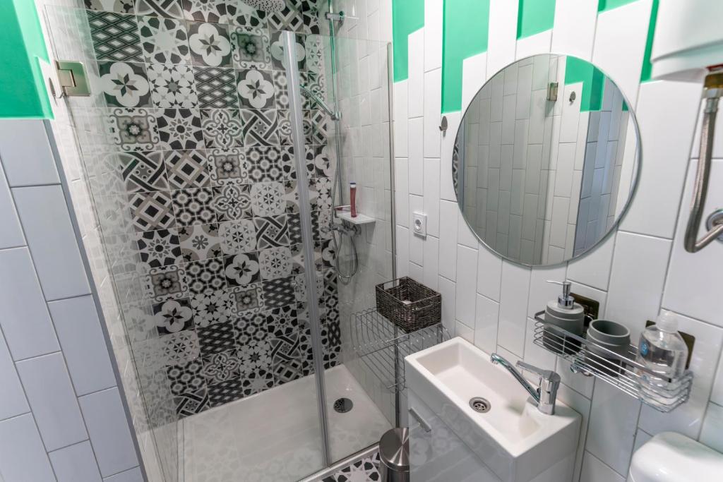 a bathroom with a shower and a sink and a mirror at Apartman Ana Osijek in Osijek