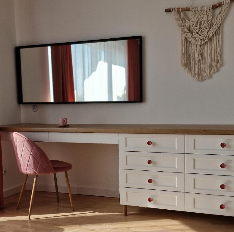 a dressing table with a mirror and a chair at Apartament Boho in Biłgoraj