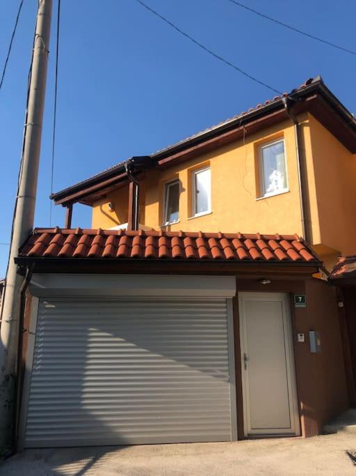 a building with a garage door in front of a house at Villa Bastion in Sarajevo