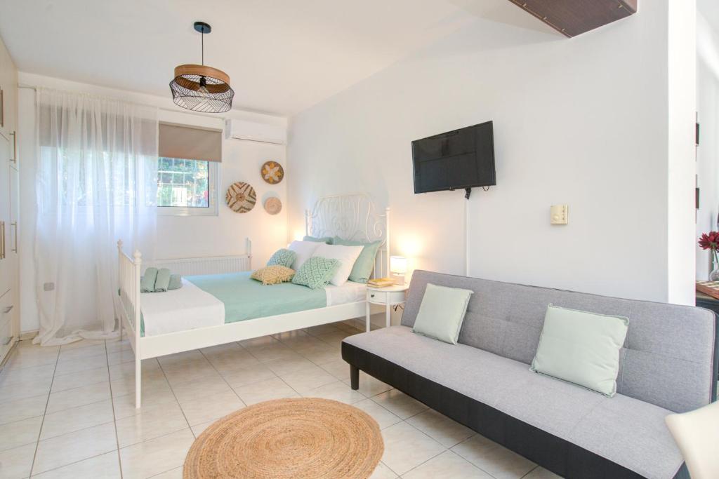 a living room with a couch and a tv at Semeli House In Diakopto, close to Beach & Odontotos in Diakopto