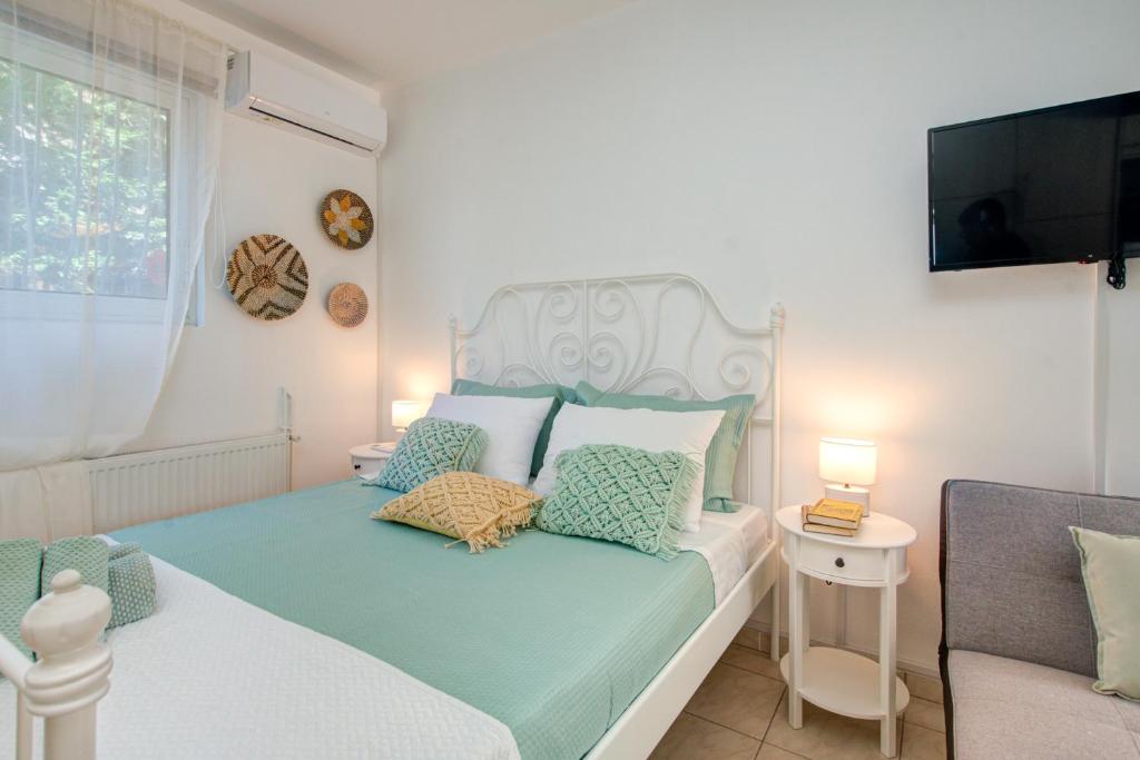 sypialnia z łóżkiem, telewizorem i kanapą w obiekcie Semeli House w mieście Diakopto