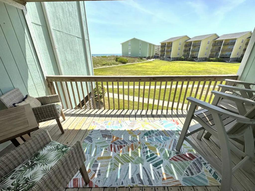 einen Balkon mit einem Stuhl, einem Tisch und einer Terrasse in der Unterkunft Ocean View & Easy Beach Access! in Surf City