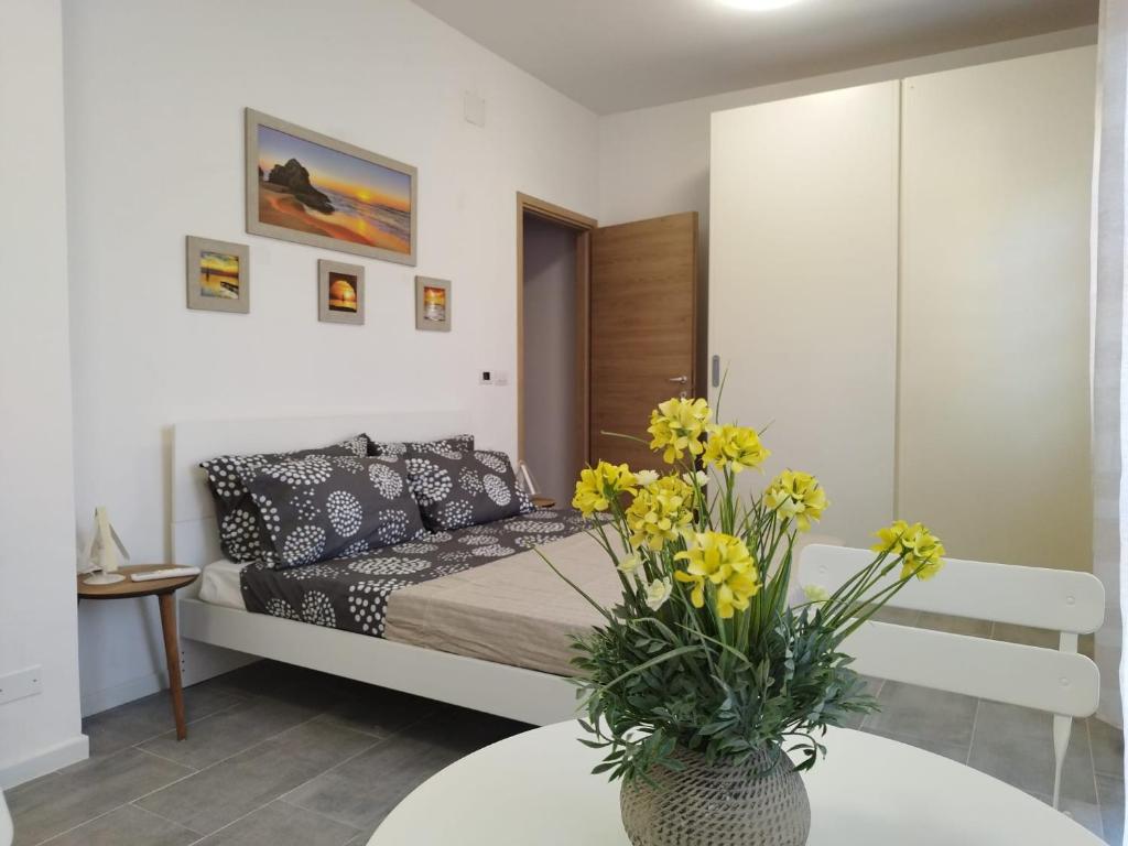 a living room with a bed and a table with flowers at b&b Casa Balai 72 a 150 mt dal mare in Porto Torres