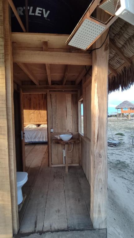 estructura de madera con lavabo y cama en Pousada Amor Do Arpoador en Tutóia