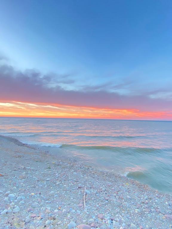 a view of the ocean at sunset with a rocky beach at Shady Shores RV Resort & Campground 