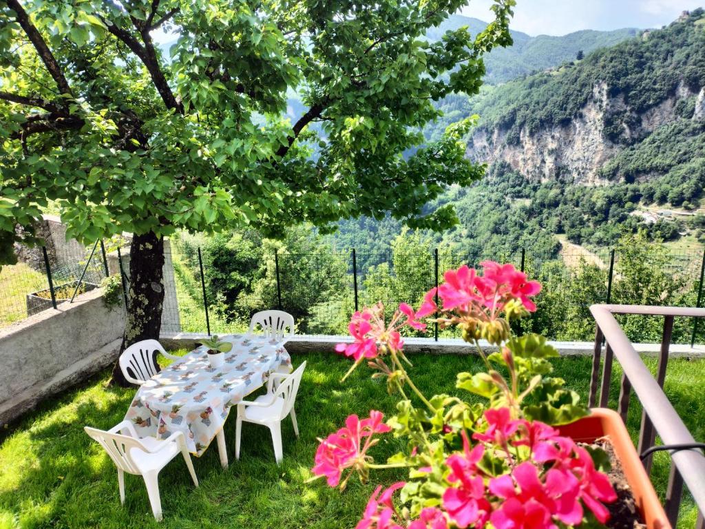 einen Tisch und Stühle unter einem Baum mit rosa Blumen in der Unterkunft Casa Butterfly in Verni