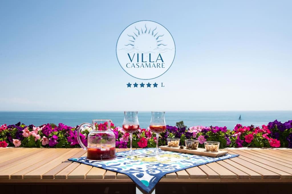 einen Tisch mit Gläsern Wein und Kerzen am Strand in der Unterkunft [Mare privato] Villa Casamare in Acireale