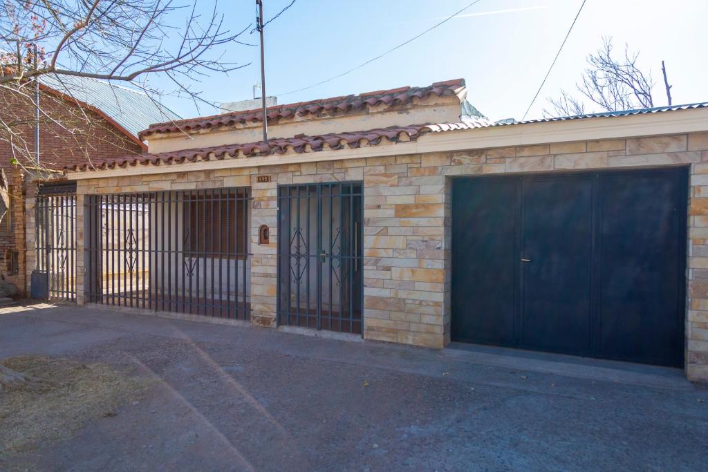 un edificio de ladrillo con un garaje con una puerta negra en Casa San Rafael en San Rafael