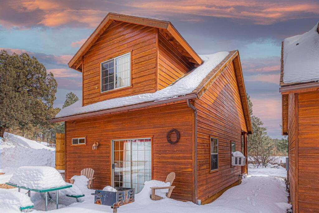 eine Holzhütte im Schnee mit einem Tisch und Stühlen in der Unterkunft Cabin#2 Elk Hallow - Pet Friendly - Sleeps 6 - Playground & Game Room in Payson