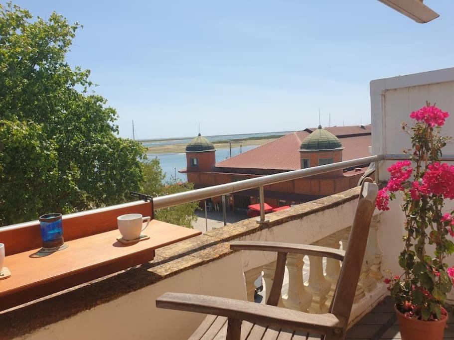 a balcony with a table and a chair on a balcony at AS CEGONHAS - ALOJAMENTo LOCAL in Olhão