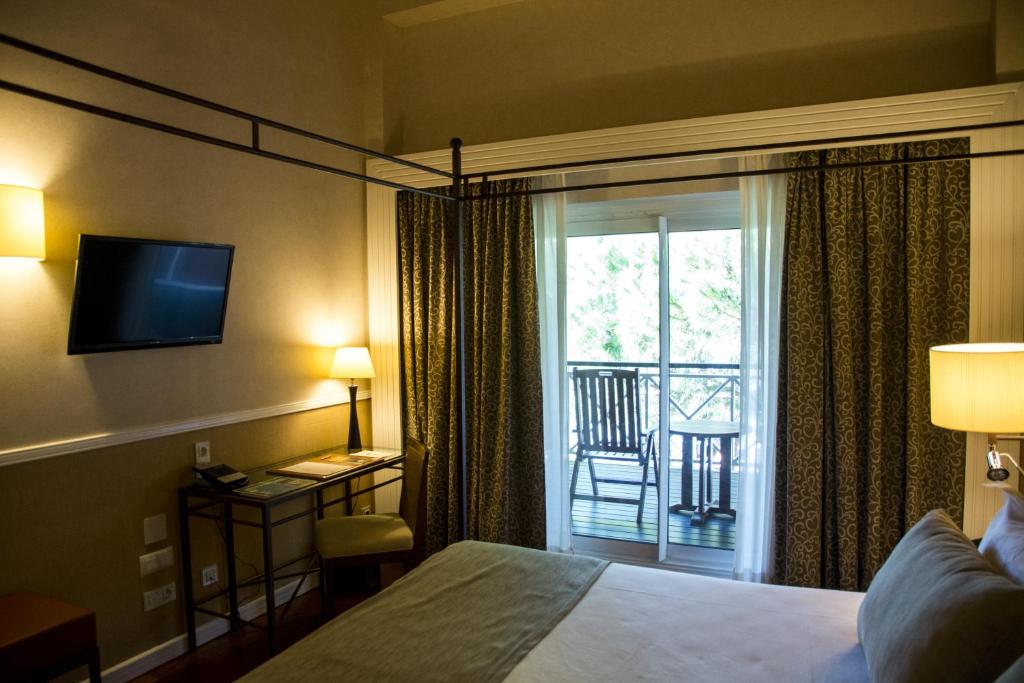 a hotel room with a bed and a balcony at Hotel Nuevo Portil Golf in El Rompido